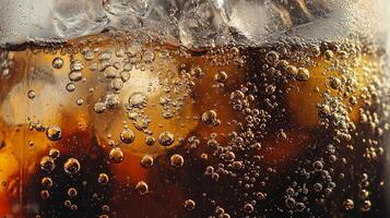 A glass of soda with ice cubes in it. The bubbles in the soda are rising to the top photo