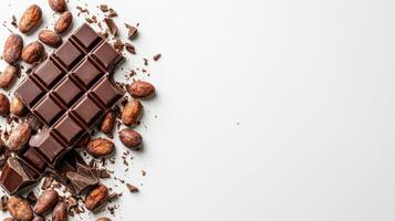 Chocolate bar broken into pieces with cocoa beans on white background photo