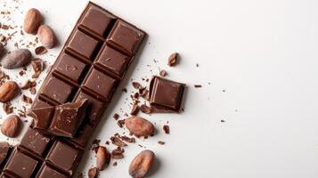 Chocolate bar broken into pieces with cocoa beans on white background photo