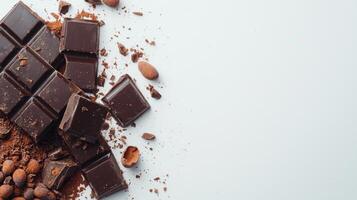 Chocolate bar broken into pieces with cocoa beans on white background photo
