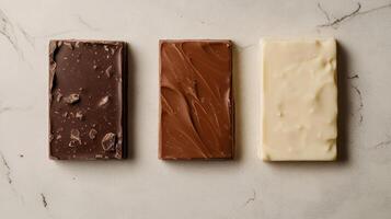 Dark, milk, and white chocolate varieties side by side. Chocolate pieces in diffrent color photo