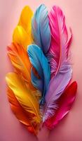 A colorful arrangement of feathers on a pink background. The feathers are of different colors and sizes, creating a vibrant and lively scene. Concept of freedom and natural beauty photo
