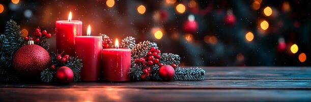 A Christmas tree with three red candles on it. The candles are lit and surrounded by red berries photo
