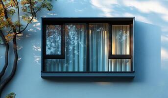 A window with curtains and a tree in the background. The curtains are white and the window is black photo