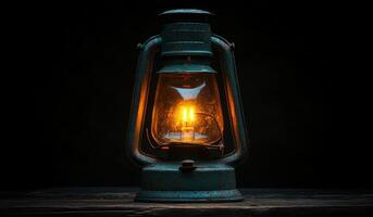 A lantern with a light inside of it is lit up. The lantern is sitting on a wooden surface photo