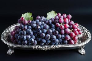 Fresh grapes placed elegantly on a silver platter against a dark background photo
