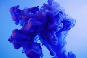 Colorful blue ink swirling in water creating abstract patterns during artistic demonstration photo