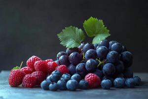 Freshly harvested berries and grapes arranged elegantly on a dark surface in natural light photo