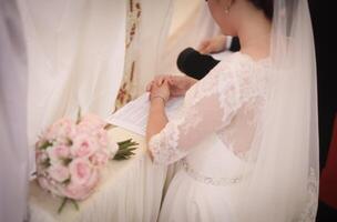 A bride and groom are sitting at a table with a wedding cake photo
