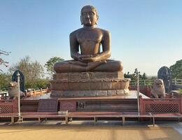 A large statue of buddha sitting on a bench photo