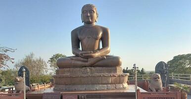 A large statue of buddha sitting on a stone photo