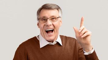 Eureka. Excited Senior Man Having Idea Posing Pointing Finger Up Over Gray Studio Background. Panorama photo