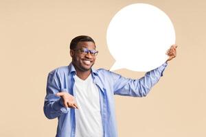 Thought. Funny Black Man Holding Empty Speech Bubble Standing Over Yellow Studio Background. Mockup photo
