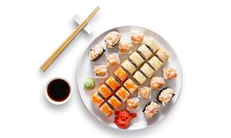 Japanese food restaurant, sushi maki gunkan roll plate or platter set. Set for two with chopsticks, ginger, soy, wasabi. Sushi isolated at white background. Top view, flat lay. photo