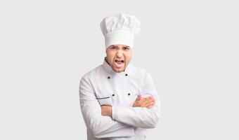 Angry Chef Man Shouting Looking At Camera Crossing Hands Standing In Studio On White Background. Panorama photo