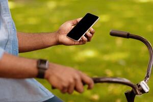 Smart ride. Unrecognizable black guy holding smartphone with blank screen using navigation app, closeup photo