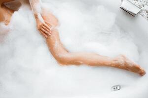 Woman Body In Bath Foam, Top view. Enjoying And Relaxing In Spa Hotel photo