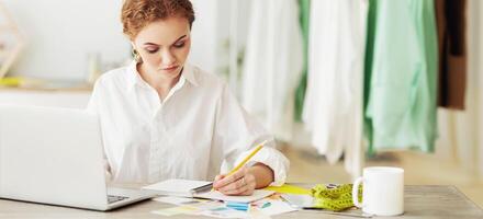 To Do List Concept. Red-haired girl sitting at desk, writing in notebook, working and studying at home, copy space photo