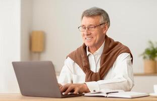 Happy Senior Man Working On Laptop Computer Sitting In Modern Office. No Ageism Concept. Selective Focus photo