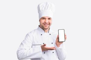 Restaurant Chef Showing Cellphone With Empty Screen Recommending Food Delivery Service Standing On White Studio Background. Panorama photo