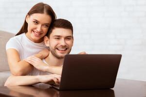 Freelance Lifestyle. Happy Guy Working On Laptop Sitting With Girlfriend On Couch At Home. Selective Focus photo