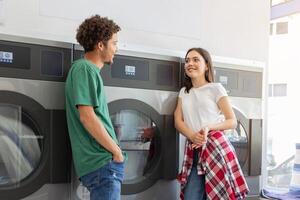A young man and woman share a light-hearted conversation at a laundromat, surrounded by washing machines. The atmosphere is relaxed and friendly as they wait for laundry. photo