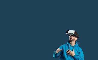 A young man wearing a virtual reality headset expresses excitement as he interacts with a digital environment, showcasing the engaging nature of modern technology, copy space photo