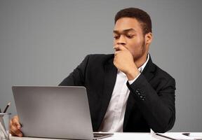 Focused Man. Portrait of afro businessman using laptop, watching webinar to improve skills, copyspace, white wall photo
