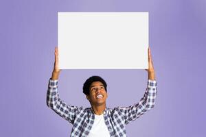 Advertisement. Student holding blank banner with copy space for your text, pink background photo