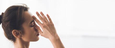 A woman performs a seated yoga twist in a well-lit studio, enjoying the calm and focus of her morning practice, copy space photo