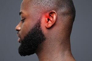 Side view of afro man with inflamed ear, close up photo
