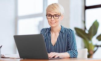 Smiling Lady Working On Laptop Computer Typing Business Report Sitting In Modern Office. Selective Focus photo