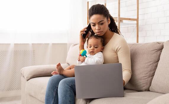 ocupado africano mamá trabajando en ordenador portátil participación bebé niñito y hablar en teléfono sentado en sofá a hogar. negro madre trabajos de lejos cuidando para niño durante maternidad salir. Lanza libre trabajo y maternidad foto