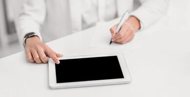Writing Ideas. Unrecognizable woman using touch tablet and taking notes. Mock up photo