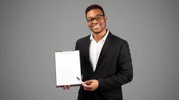African American Man Showing Blank Clipboard, Pointing At Copy Space With Pen. Panorama photo