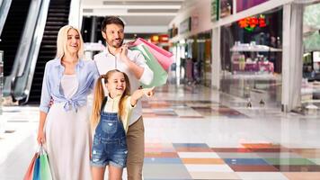 A young family, consisting of a mother, father, and daughter, is walking through a shopping mall. They are holding colorful shopping bags and appear to be happy, copy space photo