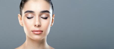 A woman standing with her eyes closed, displaying a moment of introspection or relaxation. She appears deep in thought, possibly meditating or reflecting on something. photo