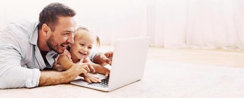 Family Time. Father and daughter making call to mother using laptop on the floor. Copy space photo