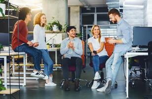 Creative team having discussion on new design project in office, informal friendly atmosphere at work photo