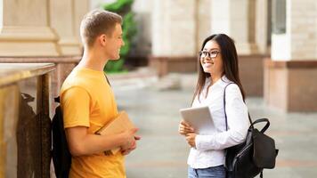Classmates talking in college campus, having break between classes photo
