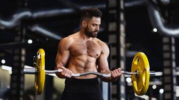A man with a beard lifts weights in a gym, focused on his exercise. photo