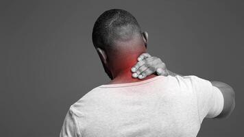 Black guy suffering from pain in neck. Symptom of cervical chondrosis. Inflammation of vertebra, back view photo