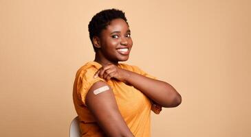 Successful Coronavirus Vaccination. Black Woman Showing Vaccinated Arm After Covid-19 Vaccine Injection Shot Posing Smiling To Camera On Beige Background. Corona Virus Immunization Concept. Panorama photo