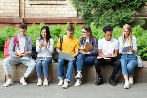 College students studying in university campus with books and devices, preparing for exams photo