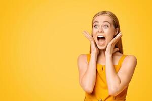 Crazy Sales. Emotional Young Woman Shouting At Copy Space With Excitement, Touching Her Face In Happy Shock, Yellow Background, Panorama photo