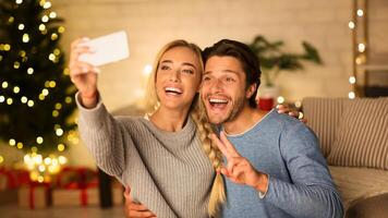 Capturing happy moments. Excited couple making selfie with Christmas tree on background photo