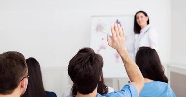 Medical lecture. Doctor giving presentation to practitioners, man having question photo