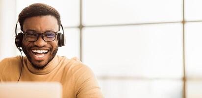 Tech Support. Portrait of handsome black sales manager with headset working in call center. Empty space photo