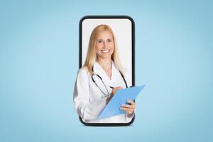 A lady doctor in a white coat with a stethoscope is shown on a smartphone screen, smiling and holding a blue clipboard while writing. This image represents the concept of telemedicine photo