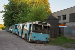 Old blue abandoned trolleybuses with broken windows in a depot photo